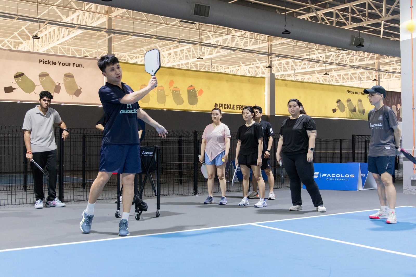 Pickleball coach Mark Teo teaching adult players correct paddle grip during a lesson